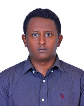 A headshot of Haben. He stares straight at the camera, wearing a blue shirt.