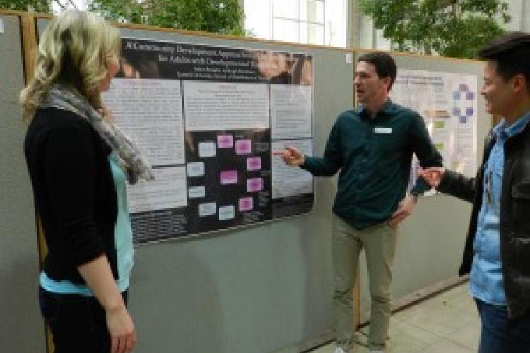 Adam Broad (C) and Ashleigh Blinkhorn (L) share their poster with fellow OT student Pablo Chang (R).