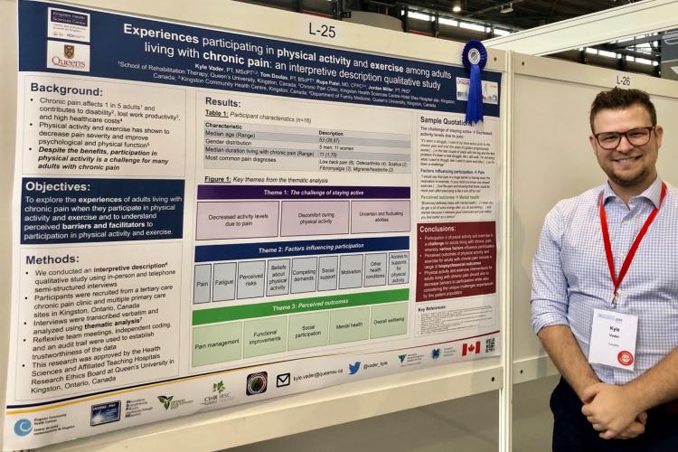 PhD stuent stood in front of poster