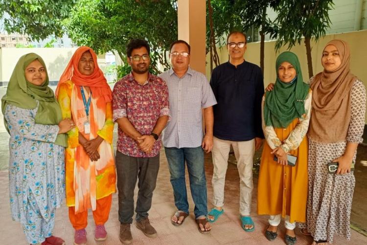 Krishno stands with six colleagues from CDD