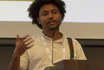 Yohannes speaks at a lectern.